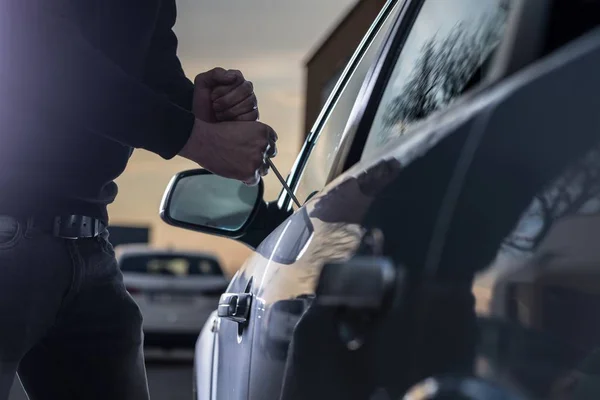 Ladrón de automóviles en pasamontañas negro tratando de entrar en el coche — Foto de Stock