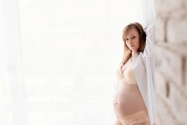 Mulher grávida em camisa branca e lingerie — Fotografia de Stock
