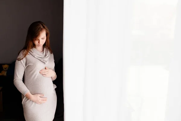 Zwangere vrouw in grijze jurk — Stockfoto