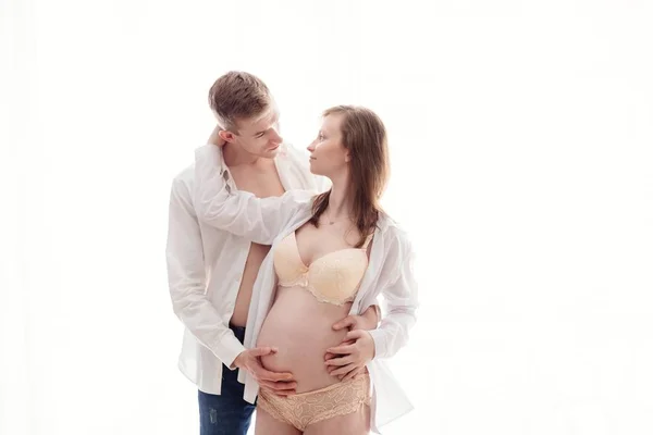 Zwangere vrouw met haar echtgenoot op witte achtergrond — Stockfoto