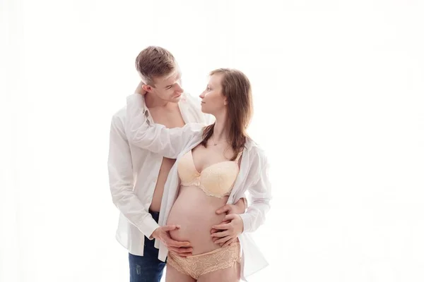 Gravid kvinna med maken på vit bakgrund — Stockfoto