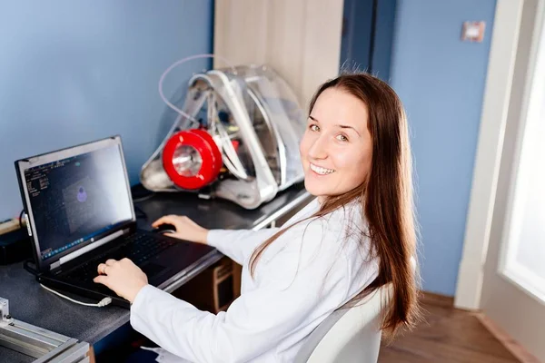 Woman in a white lab coat designs item to 3d printing — Stock Photo, Image