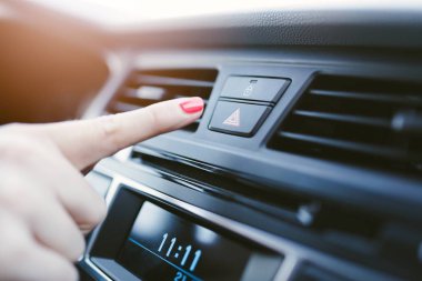 Kadın arabada acil durum ışıkları açar.