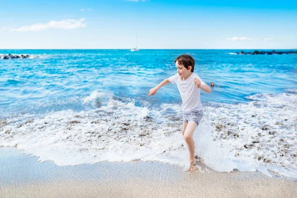 Heureux 7 ans garçon enfant jouer sur la plage — Photo