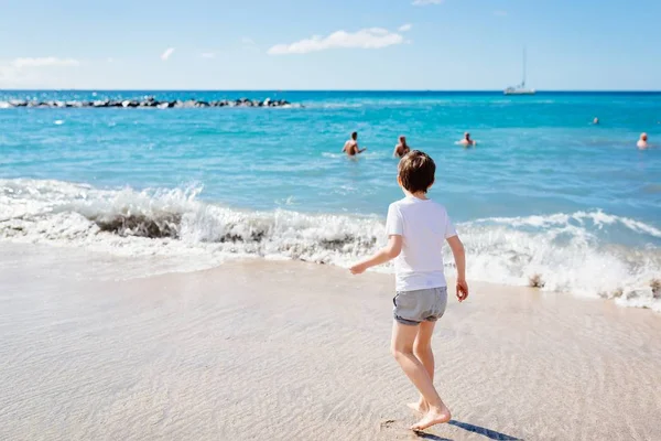 Heureux enfant de 7 ans marchant sur la plage . — Photo