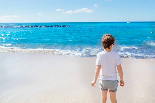 Sahilde yürüyüş mutlu 7 yaşındaki çocuk çocuk. — Stok fotoğraf