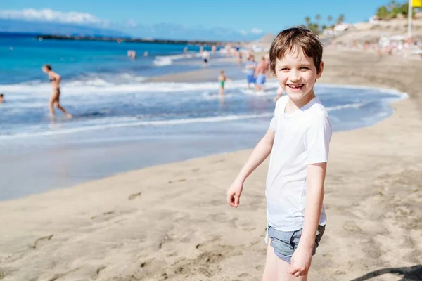 Szczęśliwa 7 lat chłopiec dziecko spaceru na plaży. — Zdjęcie stockowe