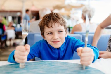 Restaurant akşam yemeği için bekleyen küçük çocuk çocuk aç