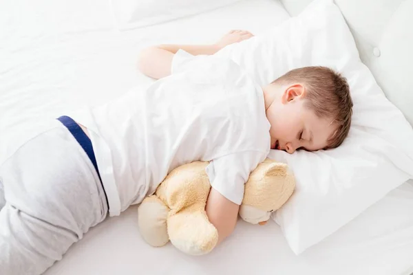 Kis fiú gyermek alszik az ágyban a gyomra — Stock Fotó
