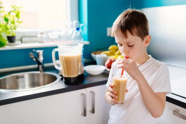 Mutlu küçük çocuk selfmade meyve kokteyl içiyor