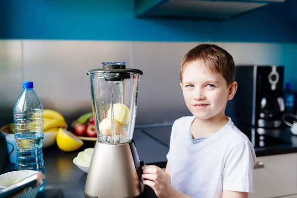 Lilla barn pojke blandning färska frukter i mixer — Stockfoto