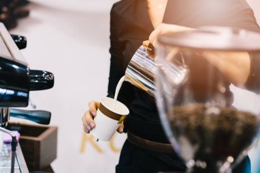 Kadın barista kahve için süt ekleme