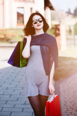 Kağıt poşetler tutan mavi yün şal kız.