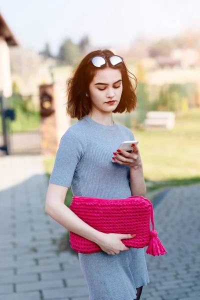 Fashion girl pulls the phone from handbag — Stock Photo, Image