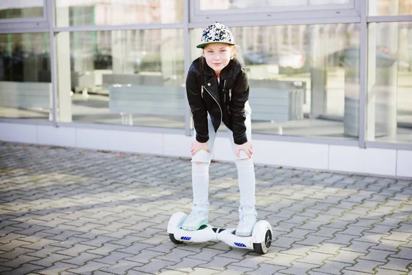 10-летняя девочка катается на самобалансирующемся электрическом скейтборде — стоковое фото