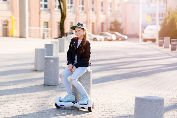 10 anos de idade menina montando no auto balanceamento skate elétrico — Fotografia de Stock