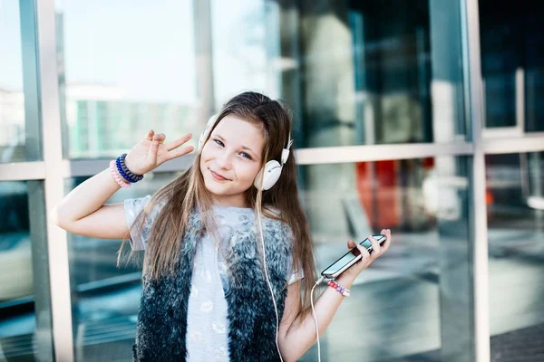 Niña escuchar la música desde su teléfono inteligente —  Fotos de Stock