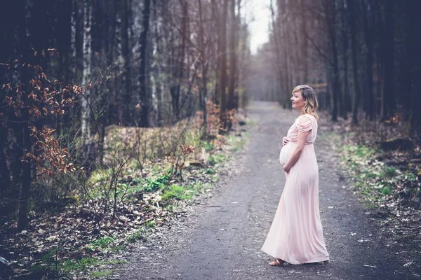 Mujer embarazada feliz disfrutando de caminar en el bosque — Foto de Stock