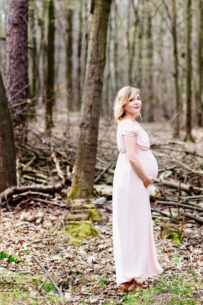 森で散歩を楽しんで幸せな妊娠中の女性 — ストック写真
