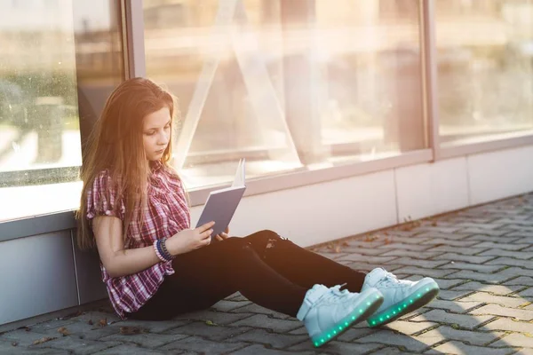 Flickan sitter och läser en bok — Stockfoto