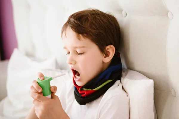 Malý chlapec vdechování jeho hrdlo s sprej inhalátor — Stock fotografie