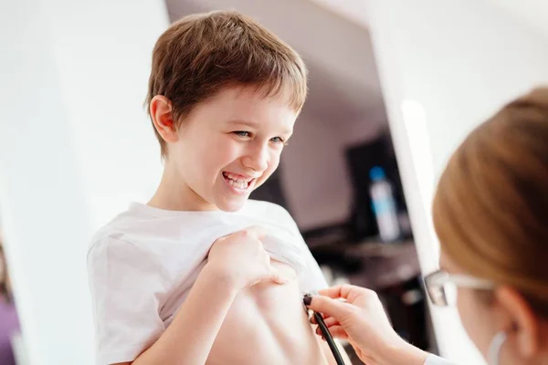 Pequeño niño sonriente está examinando por un médico — Foto de Stock