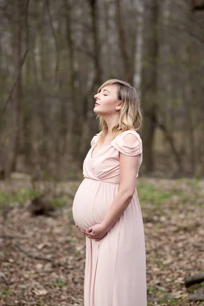 Jovem bela mulher grávida em vestido bege — Fotografia de Stock