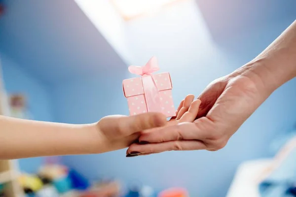 Boy's hands giving a gift to his mother - Mother's Day — Stock Photo, Image