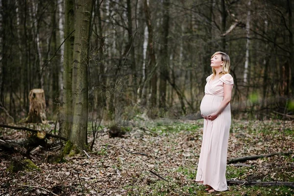 Šťastná Mladá těhotná žena uvolněná v parku — Stock fotografie