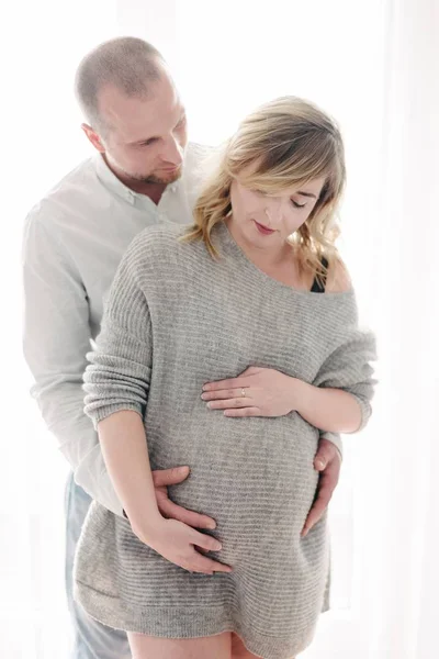 Giovane donna incinta e suo marito stanno abbracciando — Foto Stock