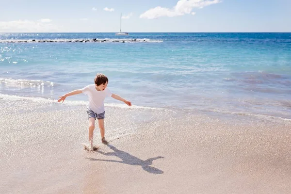 Garçon enfant heureux jouant sur la plage — Photo