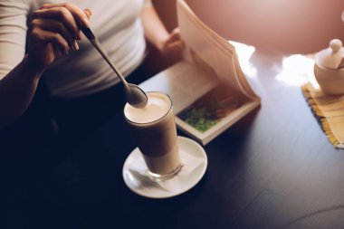 Kadın kafe müşteri Caffe sütlü kaşık ile karıştırma