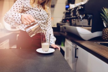 Cafe çalışan barista sıcak dökme cam süt köpürtme
