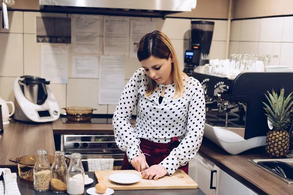 Cafe employee cuts the chocolate into small pieces. — Stock Photo, Image