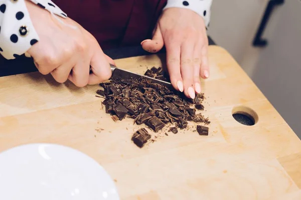 El empleado del café corta el chocolate en trozos pequeños . —  Fotos de Stock