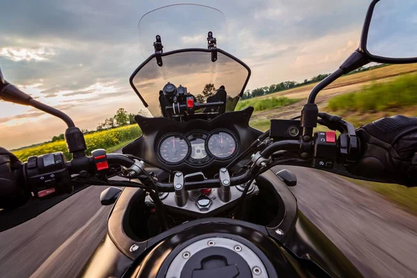 アスファルト田舎道で彼のオートバイを運転する男 — ストック写真