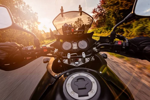 アスファルト田舎道で彼のオートバイを運転する男 — ストック写真