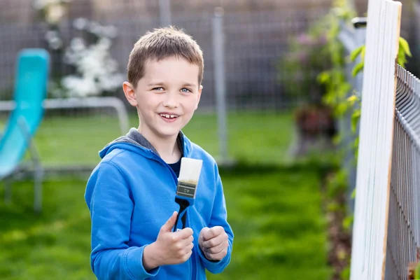 Bambino bambino che dipinge la recinzione in giardino — Foto Stock