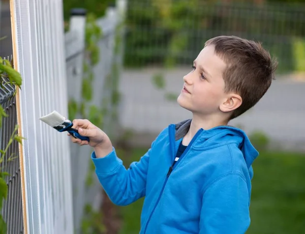 Niño pequeño pintando la valla en el jardín — Foto de Stock