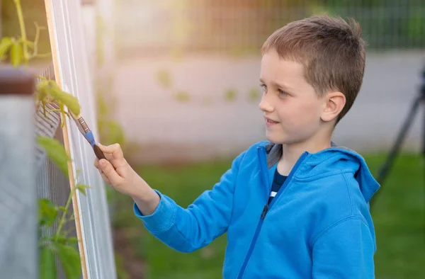 Petit garçon enfant peignant la clôture dans le jardin — Photo