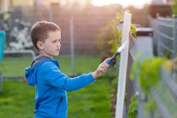 Petit garçon enfant peignant la clôture dans le jardin — Photo