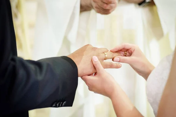 Noiva colocando uma aliança no dedo do noivo — Fotografia de Stock