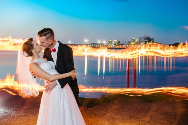 Recém-casados à beira do lago à noite — Fotografia de Stock