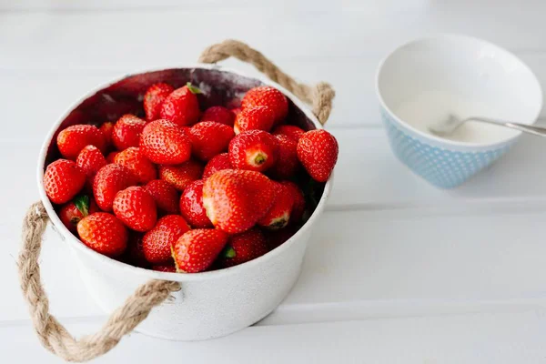 Fresh red strawberries in white bowl and sugarbowl — Stock Photo, Image