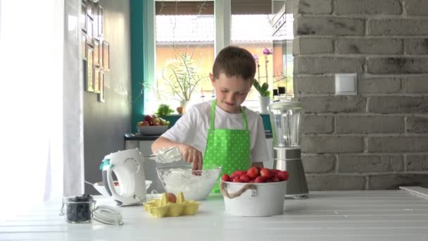 Child tasting strawberry with white cream. — Stock Video