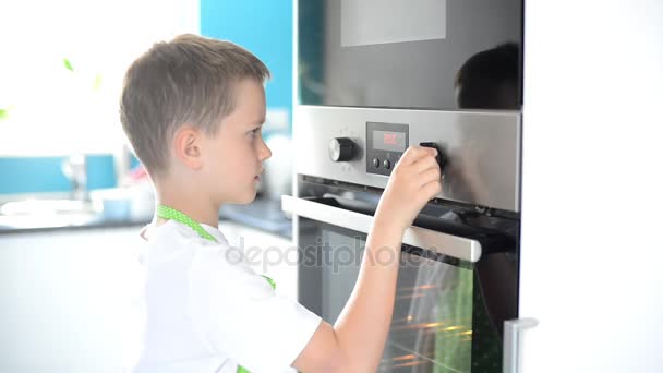Child regulates temperature of electric kitchen oven — Stock Video