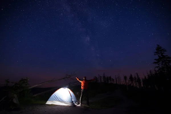 Turista con torcia vicino alla sua tenda campo di notte — Foto Stock