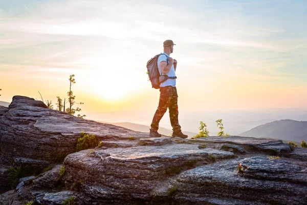 Homem turista no topo da colina ao nascer do sol . — Fotografia de Stock