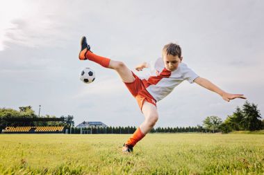 Futbol ve rulo üzerinde oynayan 8 yaşında erkek çocuk