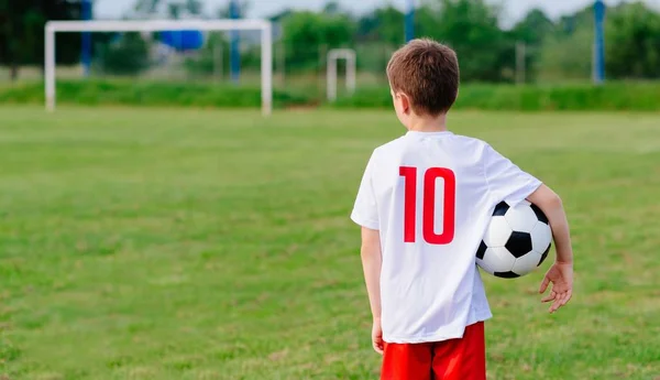 8 år gammel dreng barn holder fodbold bold - Stock-foto